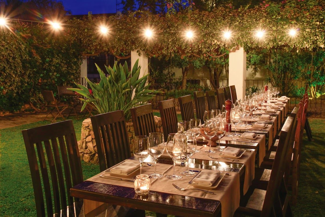 Cena de grupo en el jardín de una villa en Sitges