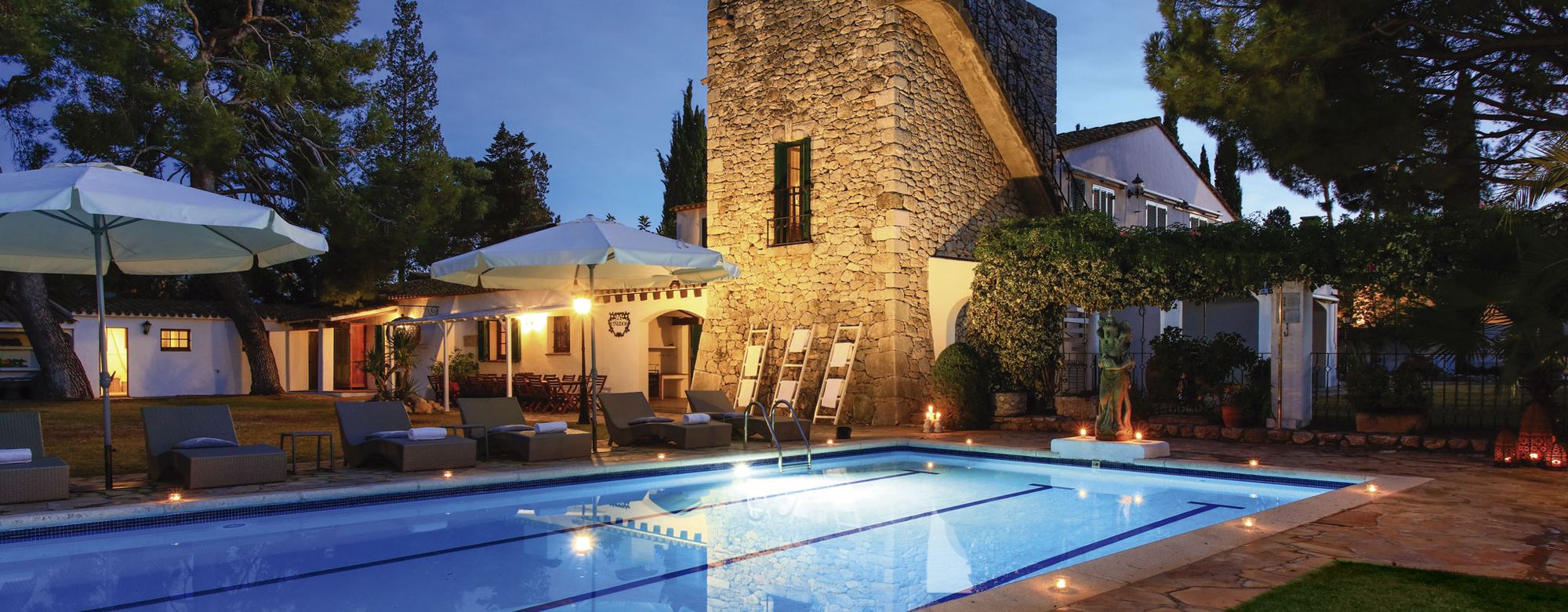 Piscina y torre de Masia Pairal al anochecer